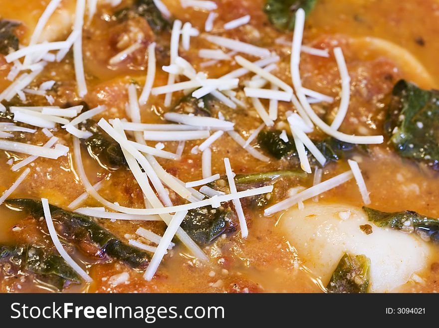 Close up of a bowl of garlic spinach tortellini soup