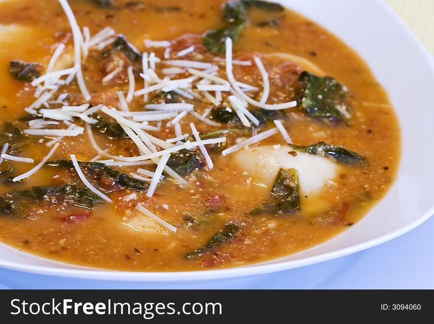 Close up of a bowl of garlic spinach tortellini soup