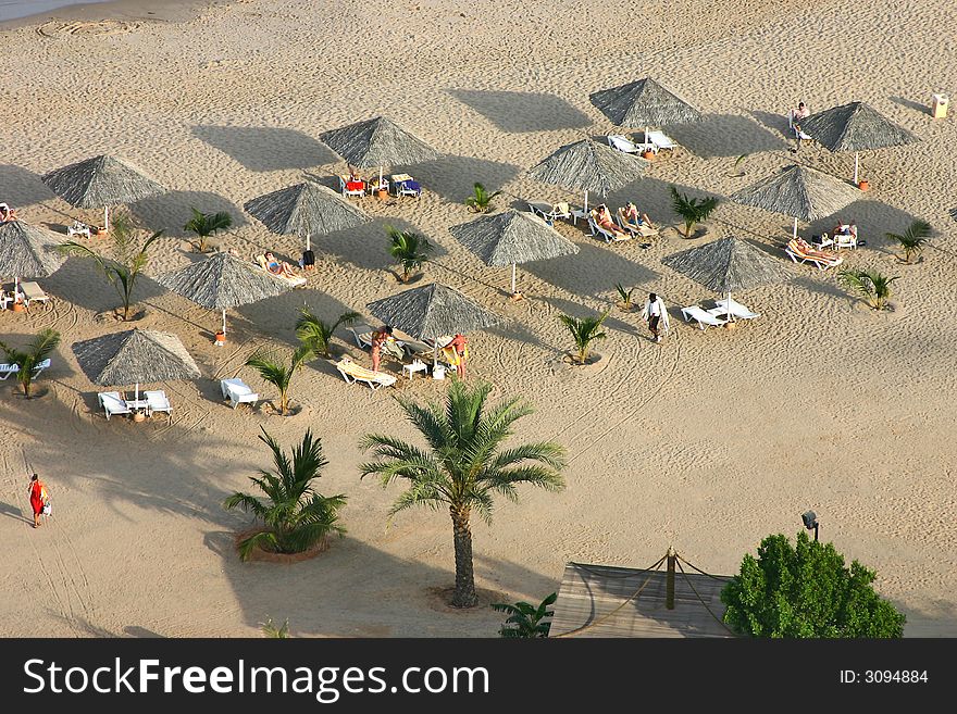 Ariel view of beach with sunbeds and straw parasols. Ariel view of beach with sunbeds and straw parasols.