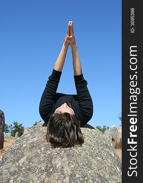 Girl lying in a rock with arms up to sky. Girl lying in a rock with arms up to sky