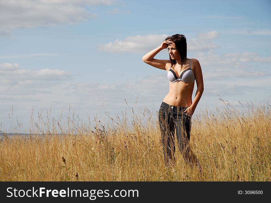Young teenage girl stands alone in sunmmer landscape. Young teenage girl stands alone in sunmmer landscape.