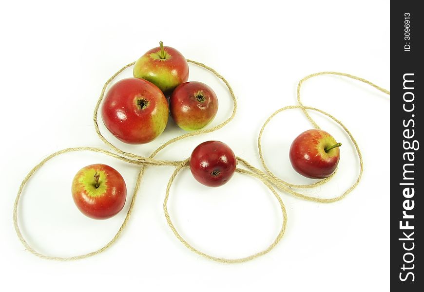 Composite: red apples and string on white background