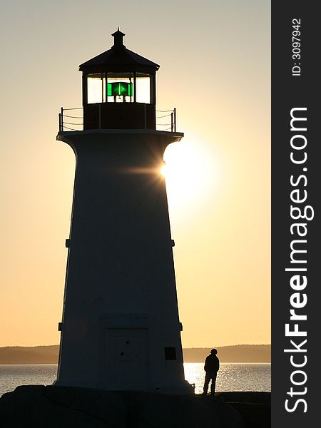 A young man looking up at the lighthouse at Peggy's Cove, Nova Scotia. A young man looking up at the lighthouse at Peggy's Cove, Nova Scotia