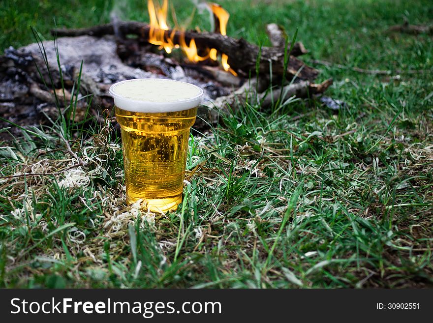 Beer with fire in nature, fresh product and good mood.