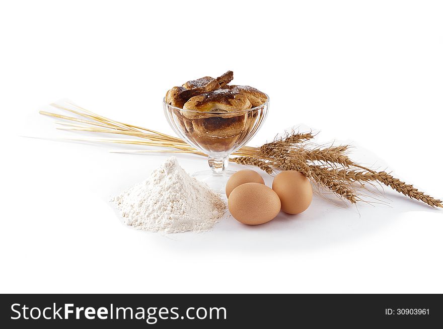 Puff pastry in piala, eggs, flour, spikelets on white background. Puff pastry in piala, eggs, flour, spikelets on white background.
