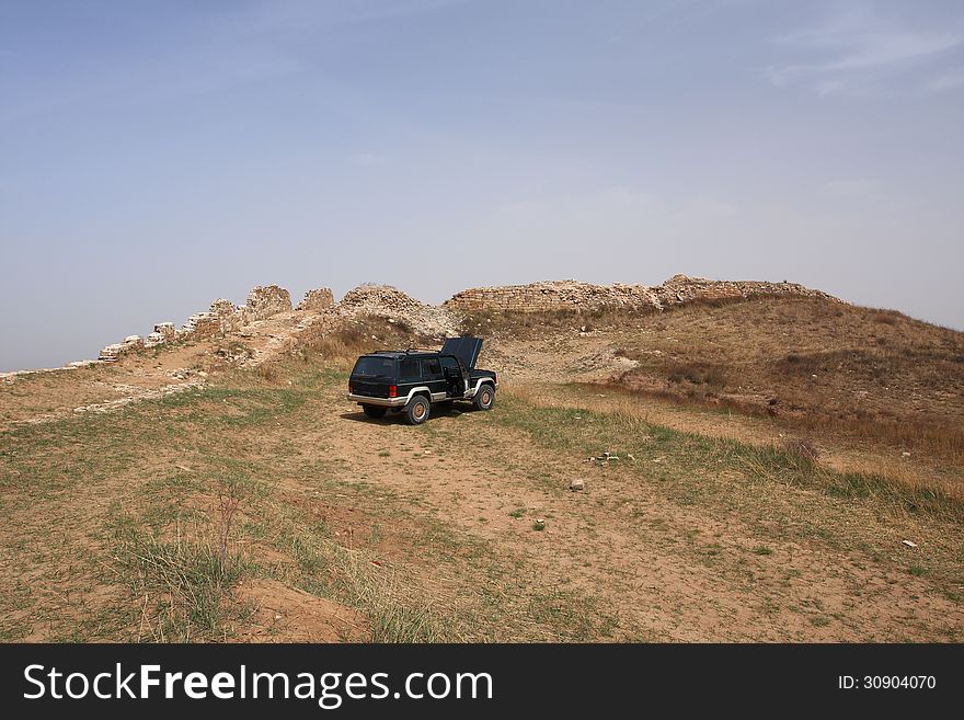 An old Jeep at the foot of the Great Wall of China