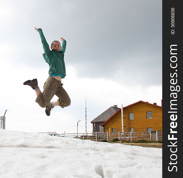 Young trekker jumping on snow