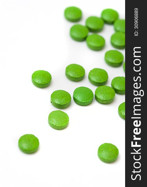 Little green pills on white background. Little green pills on white background