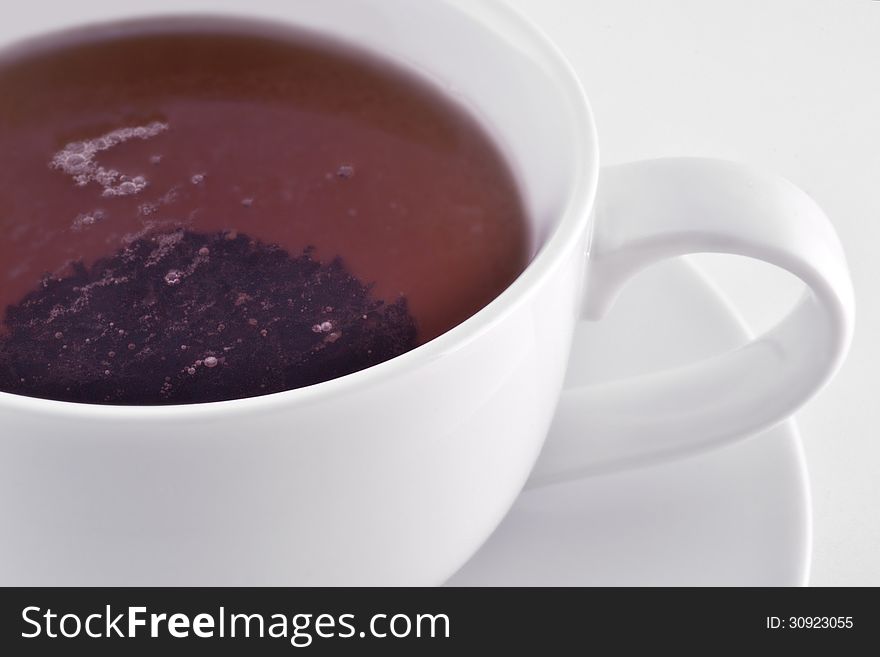 White cup with black tea macro
