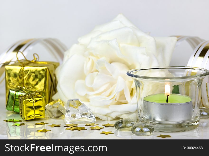 White rose, gift boxes and green burning candle. White rose, gift boxes and green burning candle