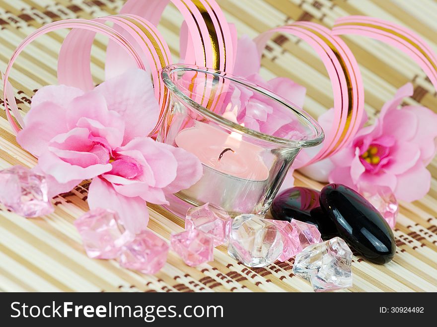 Pink flowers, burning candle and colored pieces of ice. Pink flowers, burning candle and colored pieces of ice