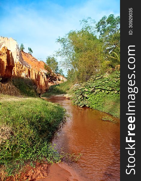 Landscape with palm tree and red river between rocks and jungle Ham Tien canyon Mui ne, Vietnam. Landscape with palm tree and red river between rocks and jungle Ham Tien canyon Mui ne, Vietnam