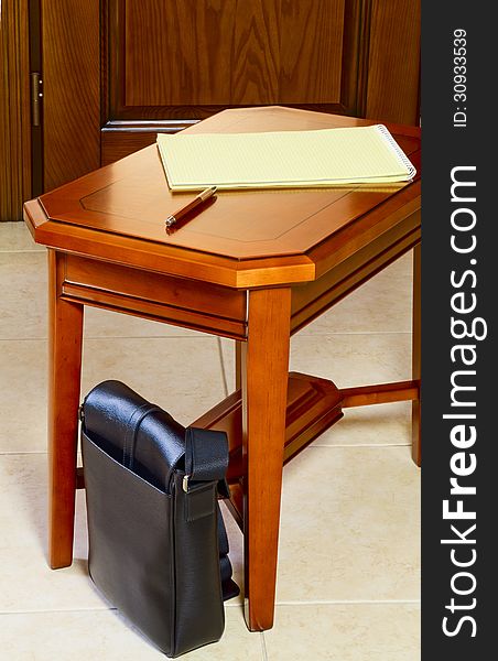 Men's bag next to the coffee table against the door. Men's bag next to the coffee table against the door