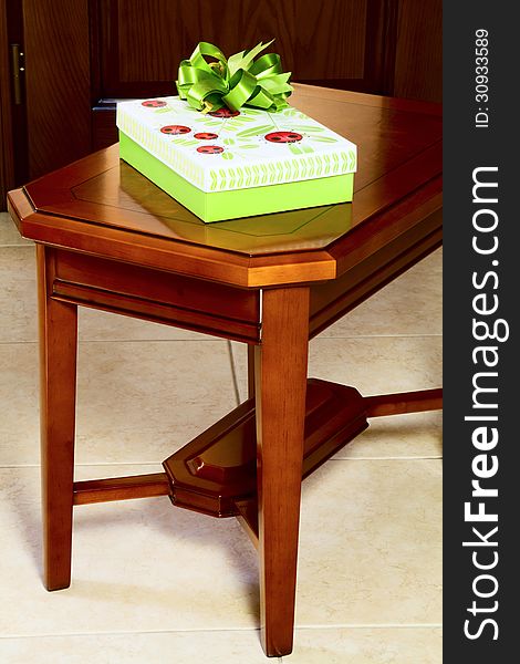 Gift in a box on the coffee table against the background of a wooden door