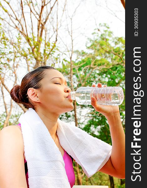 Young woman drinking water in the park