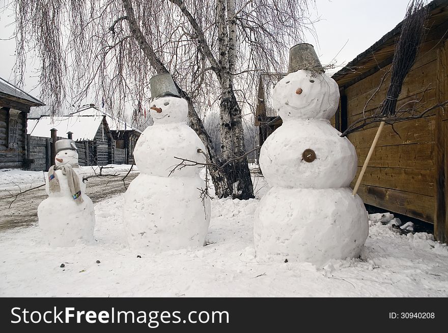 Winter. Three snowballs in a village street.