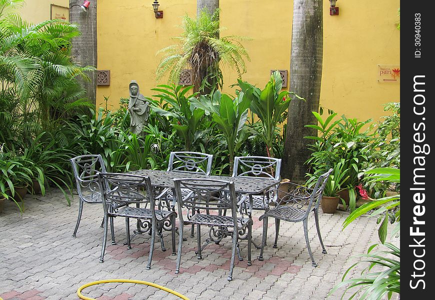 A wrought iron dining set in a garden setting