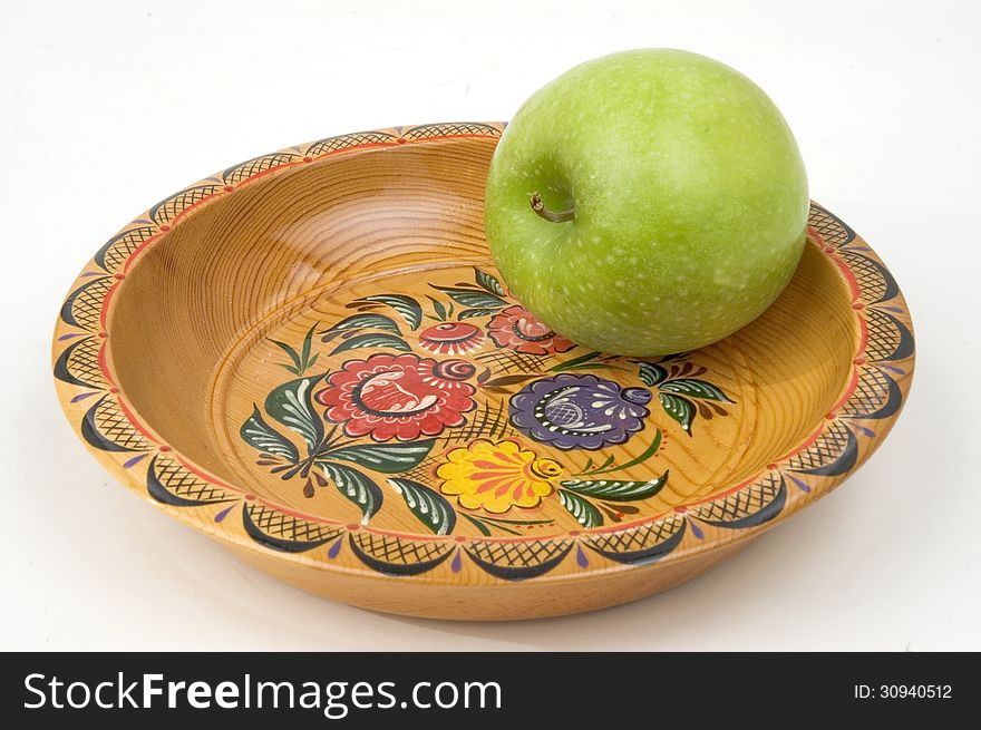 Green apple on a colour wooden plate. Green apple on a colour wooden plate.