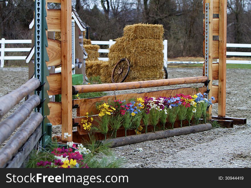 Horse jump consisting of natural wooden poles decorated with spring flowers. Horse jump consisting of natural wooden poles decorated with spring flowers.