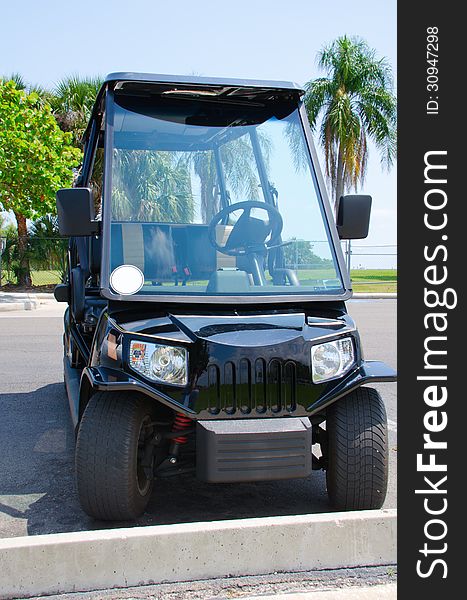 High tech expensive golf cart with headlights, full windshield and rear view mirrors