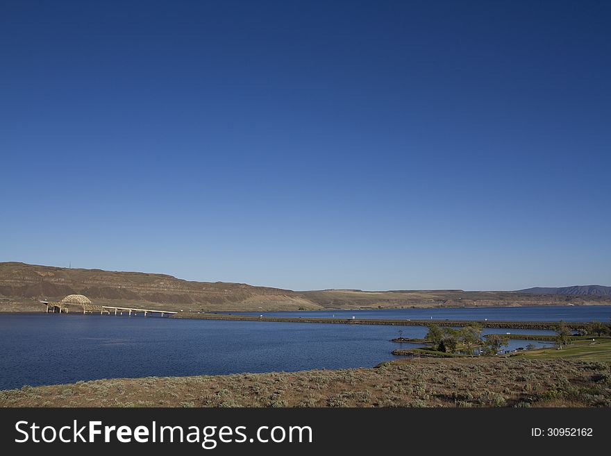 I-90 Vantage Bridge over the Columbia River Gorge in central Washington State Wide Angle with blue sky blue water rocky dry desert mountain hill Vantage