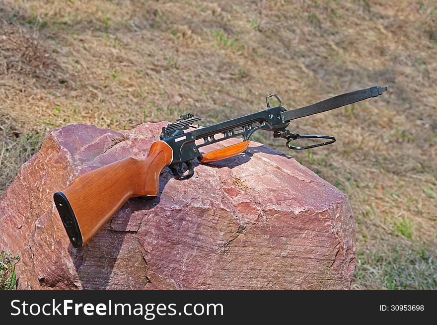 Crossbow laying on the rock in grass