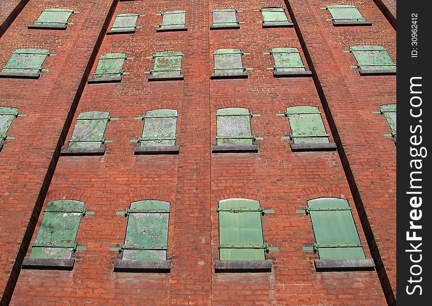 Green metal windows on brick wall.