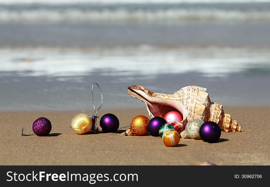 Christmas balls and seashell on the beach