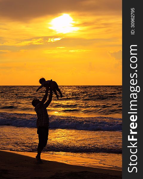 Father and daughter playing together on the beach at sunset