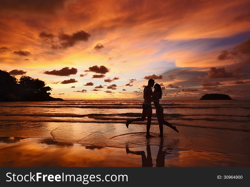 Silhouettes of lovers on a background of a sunset