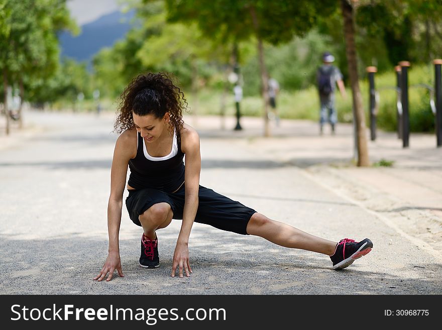 Young Woman In Sports Doing Exercise In Urban Background