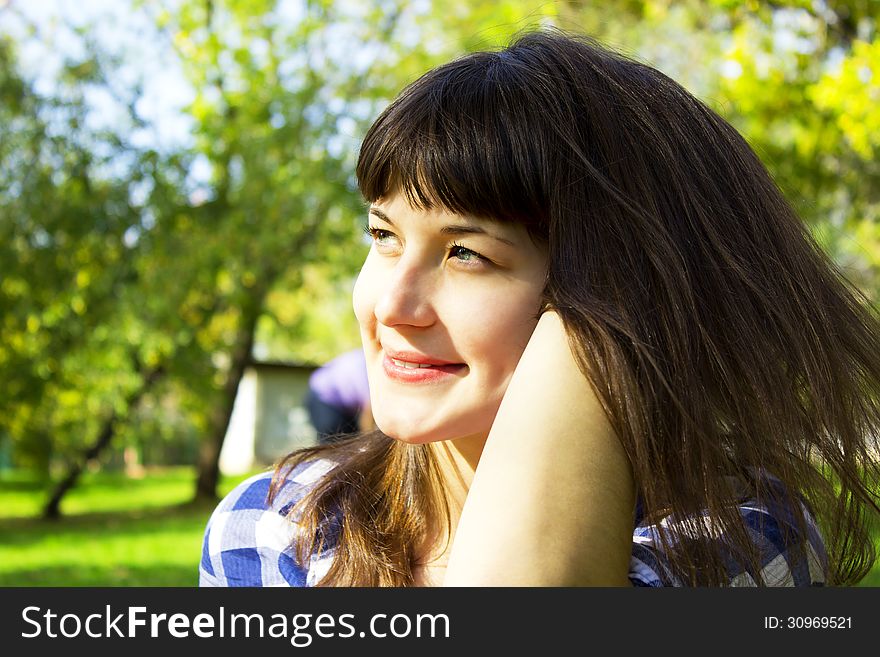 Beautiful girl in park sits on a green lawn. Beautiful girl in park sits on a green lawn
