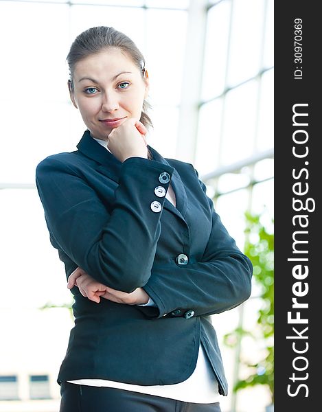 Portrait of successful business woman smiling on the background of a blurred office interior