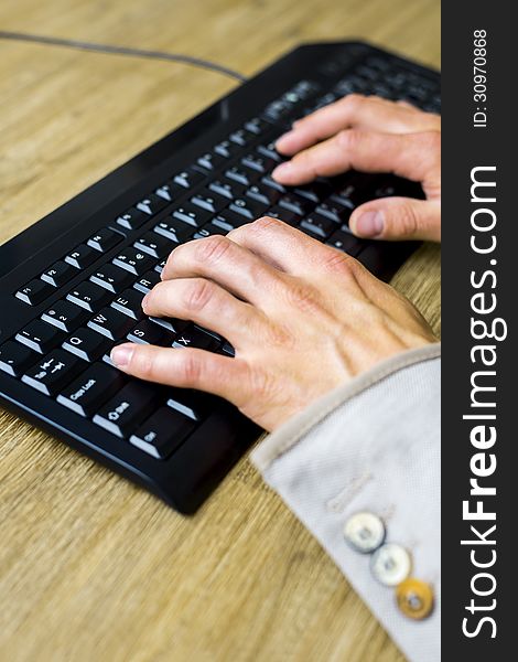 Hands typing on a black keyboard, shallow depth of field. Hands typing on a black keyboard, shallow depth of field.