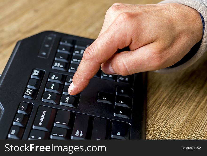 Finger about to press the delete button on a keyboard. Finger about to press the delete button on a keyboard.