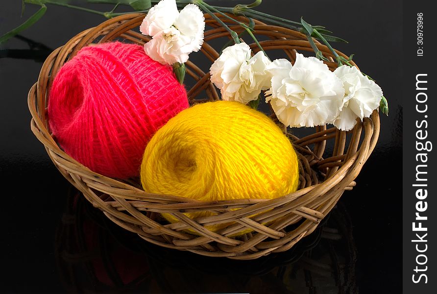 Skein of yarn in a wicker basket on a black background