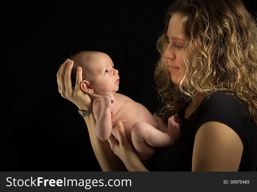 Mother holding her baby on black background. Mother holding her baby on black background