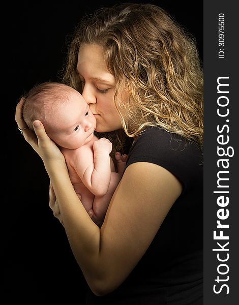 Mother holding her baby on black background. Mother holding her baby on black background