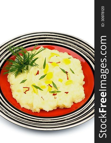 Mashed Potato Garnished with Dill, Spring Onion, Leek and Chili on Red Plate isolated on white background