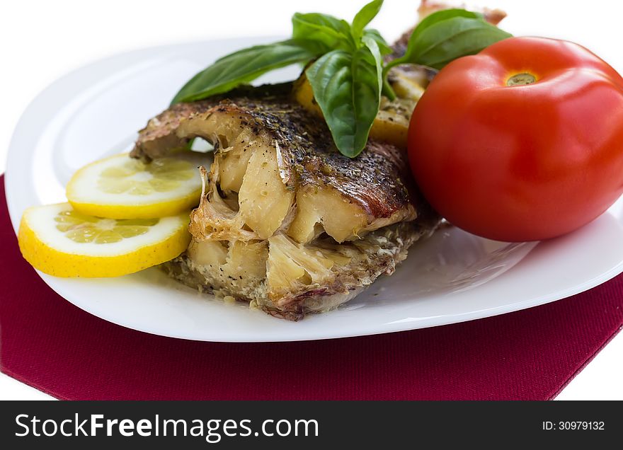 Served grilled fish with lemon and basil with tomato macro