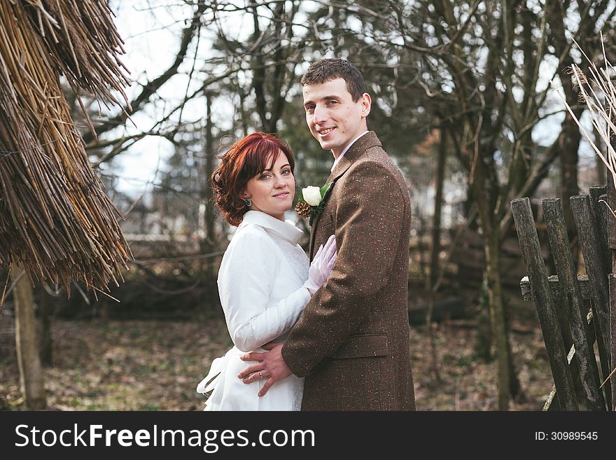 Bride and groom dressed in vintage dress and suit an holding each other in their arms. Bride and groom dressed in vintage dress and suit an holding each other in their arms.
