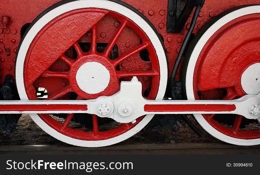 Wheels and connecting rods of an vintage steam locomotive is on the rails