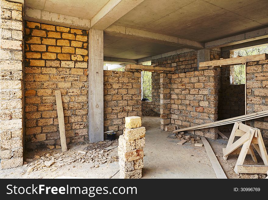 Building house of concrete frame with walls from shell rock