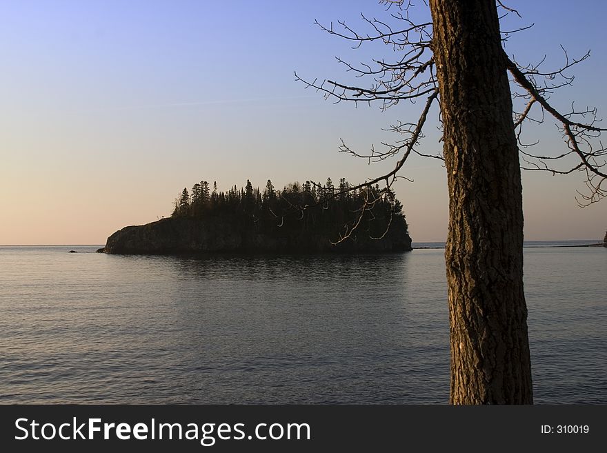 Tree on shore framing island in distance. Tree on shore framing island in distance