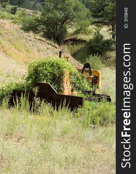 Weeds, vines and rust cover and overcome a bulldozer left parked near the South Platte River in Colorado. Weeds, vines and rust cover and overcome a bulldozer left parked near the South Platte River in Colorado.