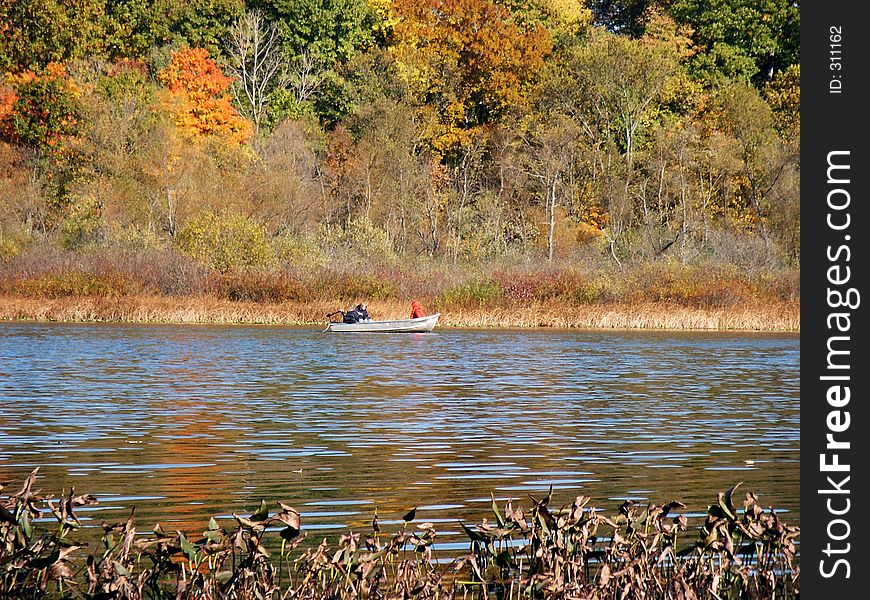 Rowboat across the lake against autumn backdrop. Rowboat across the lake against autumn backdrop