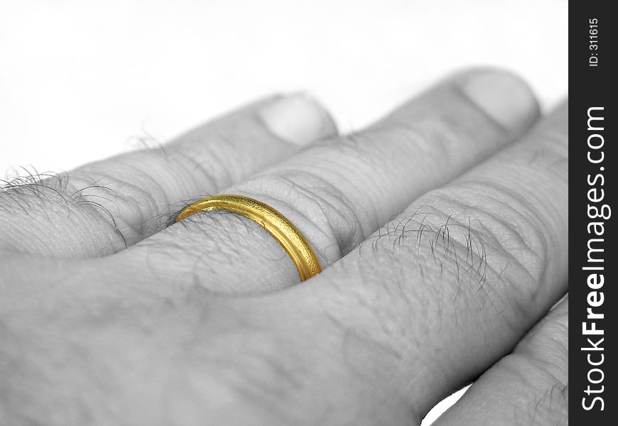 A (desaturated) hand with the wedding ring on a finger. A (desaturated) hand with the wedding ring on a finger