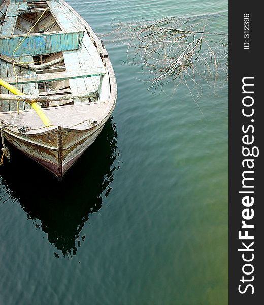 Old fishing boat casting reflections on the nile river in Egypt.