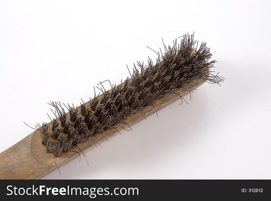 A wire brush with bristles facing up.