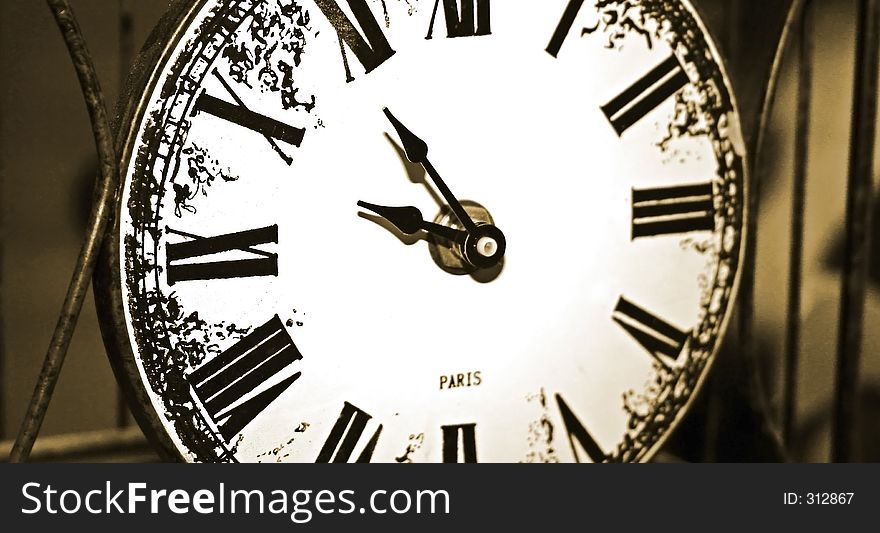 Photo of an antique clock within a metal frame. Photo of an antique clock within a metal frame